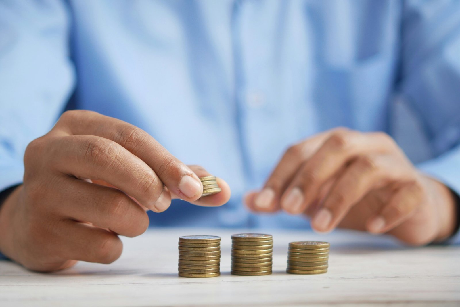 Stacking coins on a table symbolizing monthly budget savings
